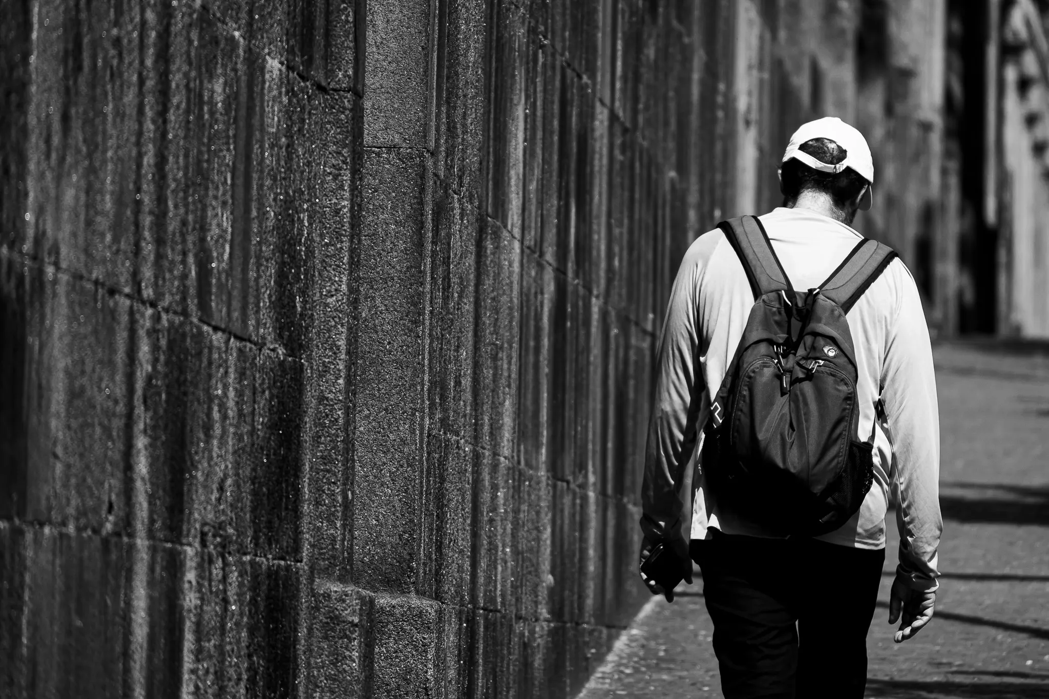 Man Walking Next to a Cemetary